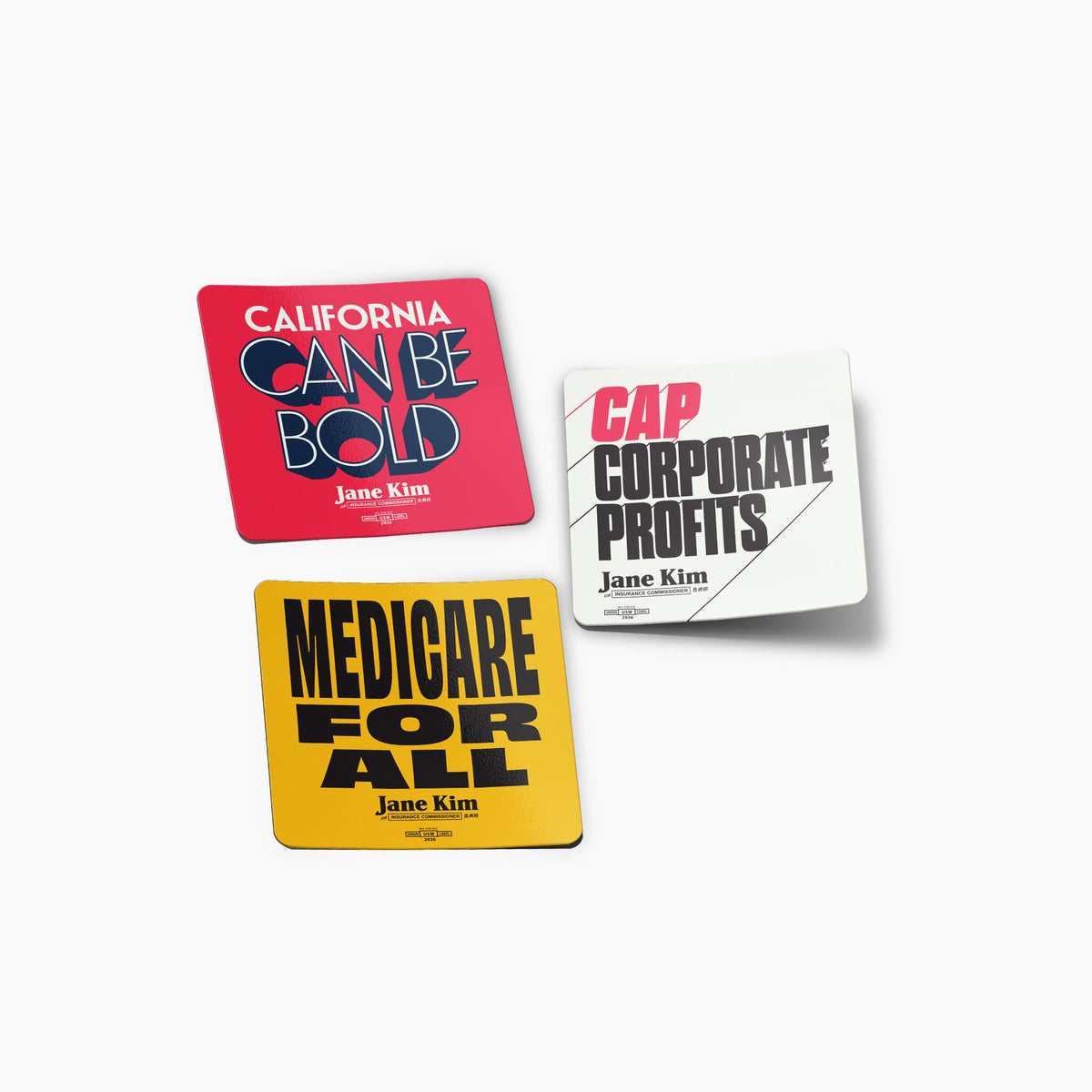 Set of three political slogan stickers in red, white, and yellow with bold black and red text.